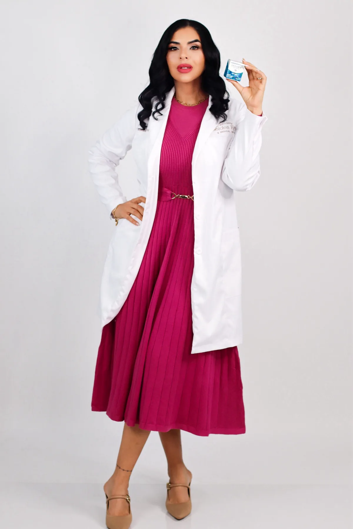 Dr. Kimberly Ayala Vega in a white coat over a pink dress at Golden Rose Wellness & Medical Spa